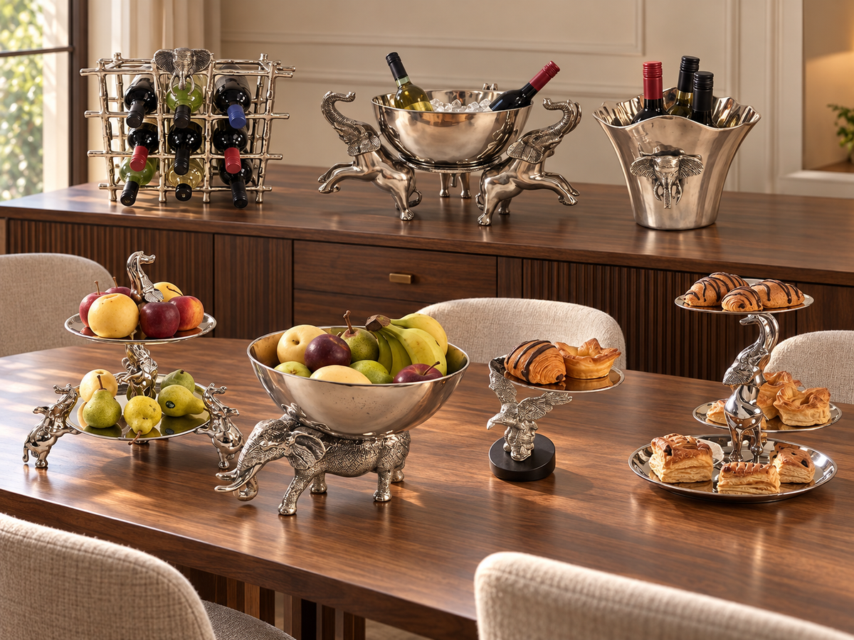 Silver animal-themed wine holders, fruit bowls and tiered serving stands arranged in a warmly lit modern dining room.